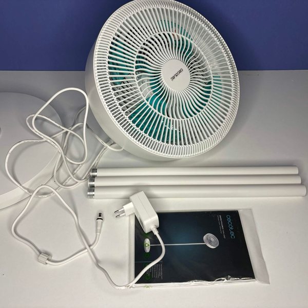 Der Lieferumfang zerlegt: Ventilatorkopf mit Kabel, Standfuß, drei Steckrohre, Netzteil und die eingeschweißte Anleitung.