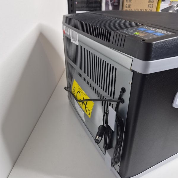 Rückseite mit Kondensator, Kabelaufwicklung und 12-V-Stecker.