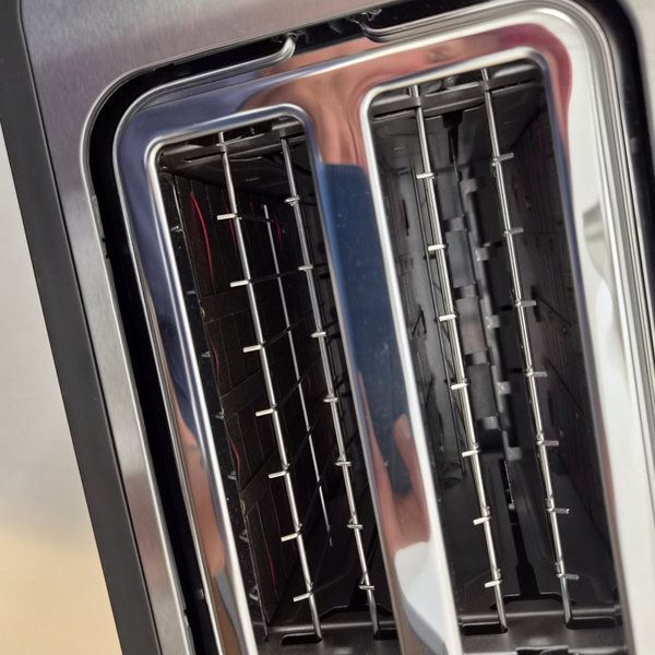 Die Röstschlitze von oben im Betrieb, mit rötlichem Schein der Heizdrähte; oben die Markierung „High-Lift“.