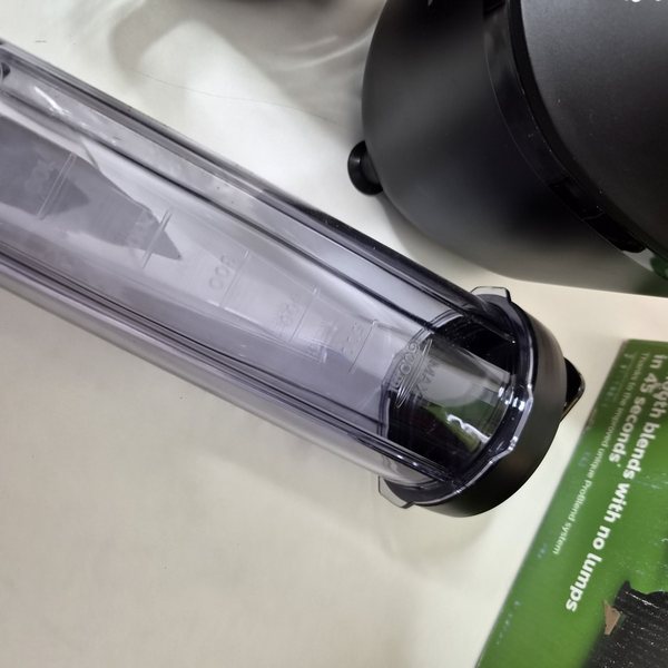 Eine To-Go-Flasche liegend, daneben eine Kartonseite mit abgeriebenem Aufdruck.