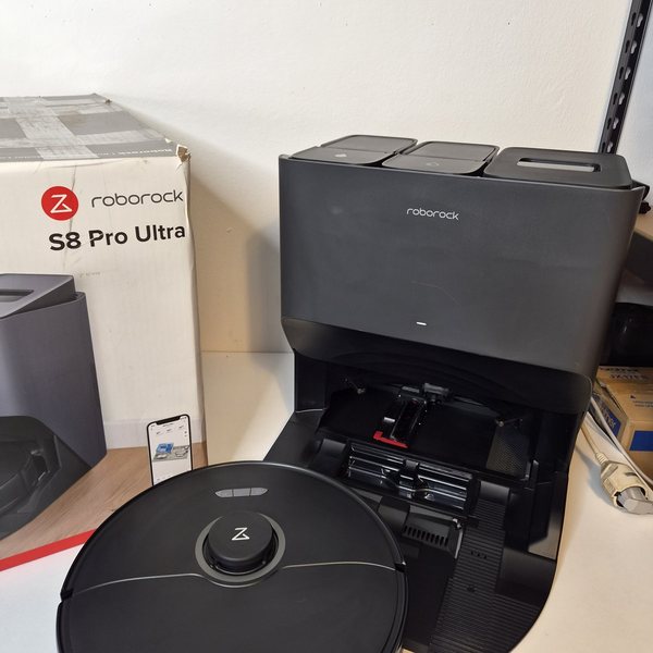 Roboter und Station, links der Originalkarton mit der Aufschrift Roborock S8 Pro Ultra.